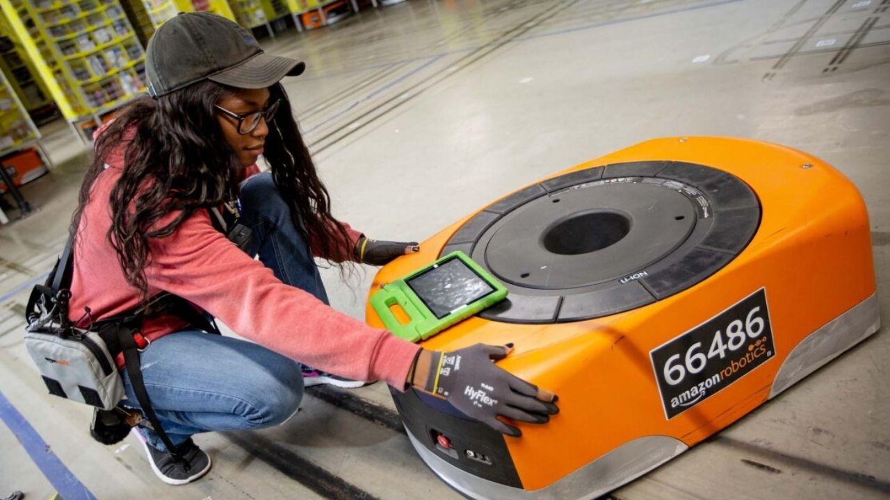 Amazon çalışanlarının depo robotu üzerinde bakım yapması