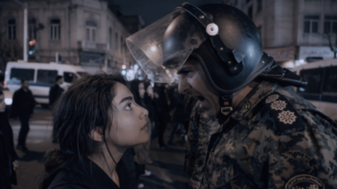 Dreams of Violets filminden bir sahne: Sokak protestosunda kasklı bir askerin karşısında duran genç bir kadın karakter